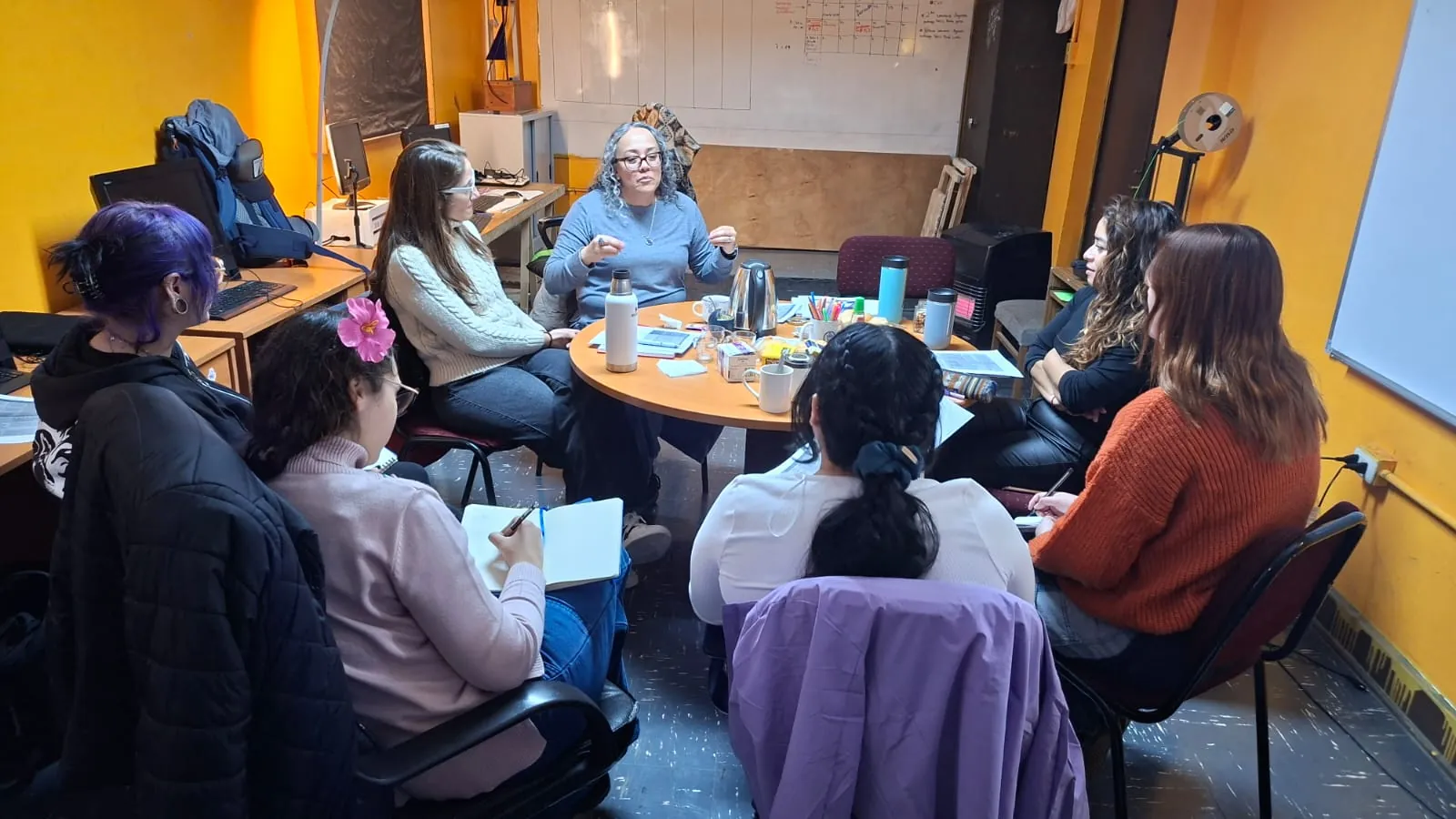Docentes conversan alrededor de una mesa de trabajo
