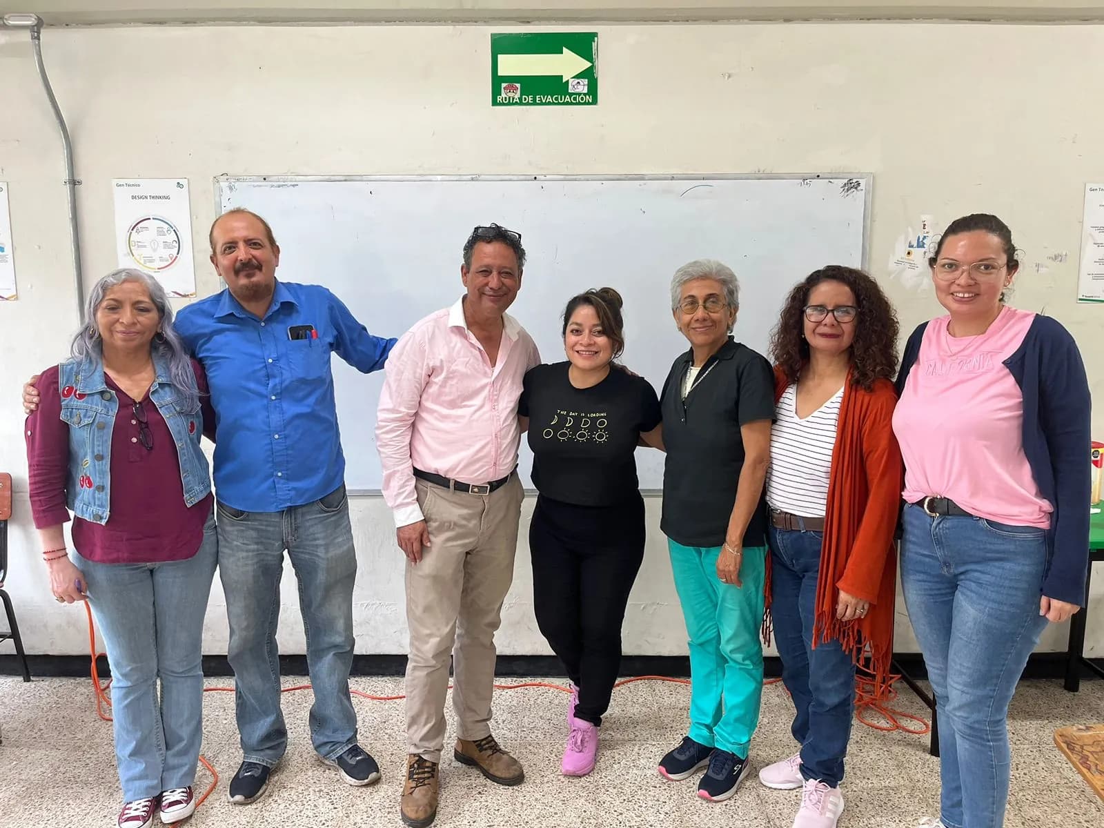 Un equipo docente reunido frente a la pizarra de su escuela