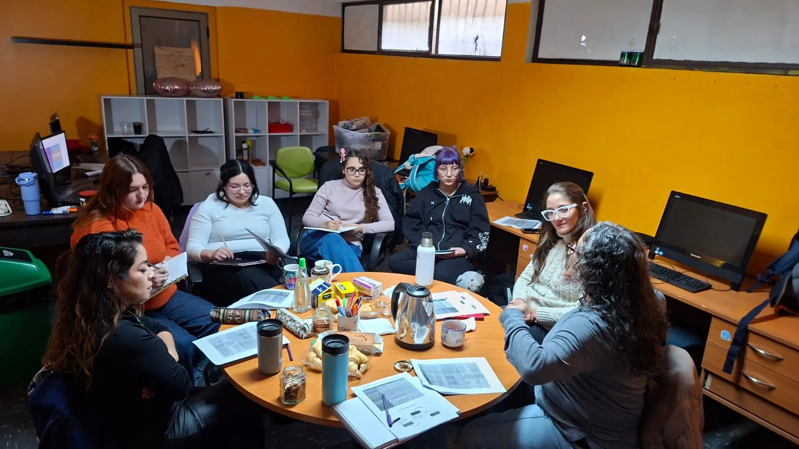 Docentes trabajan con materiales alrededor de una mesa